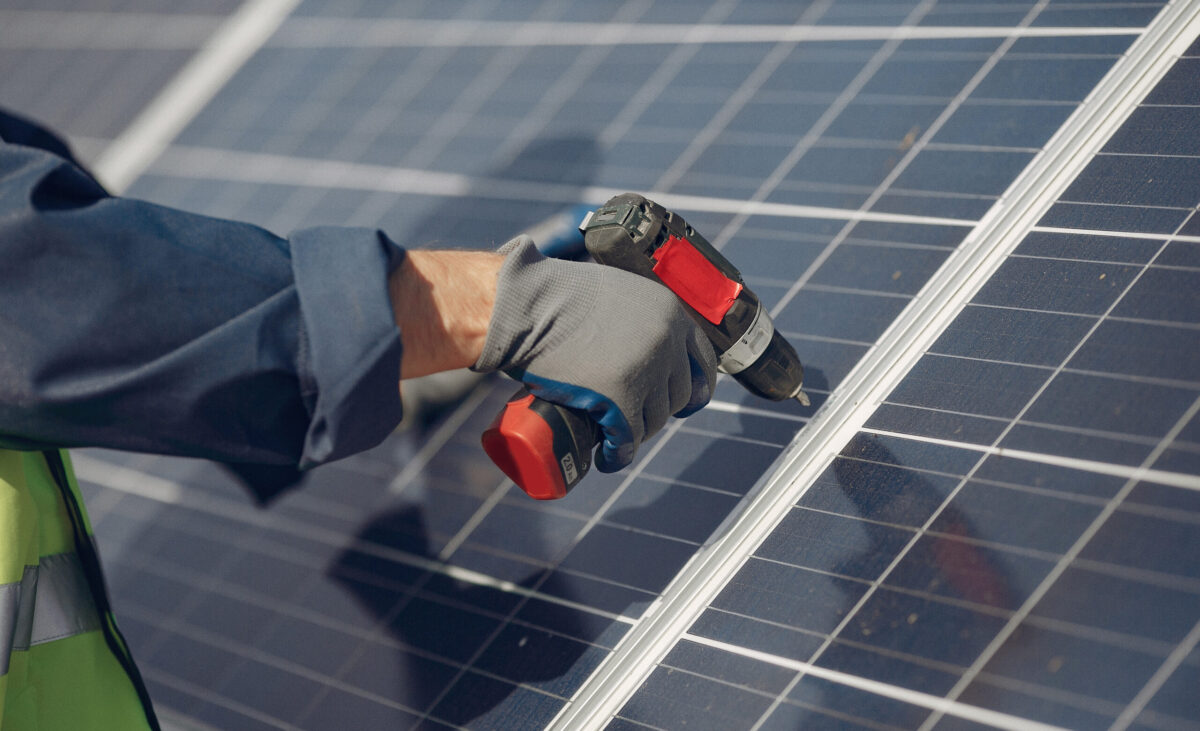 Engineer in a white helmet. Man near solar panel.